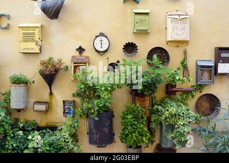 Assortimento o esposizione di piantatrici da parete vintage o riciclate, scatole di lettere e contenitori di fiori riutilizzati Saint Remy de Provence France Foto Stock