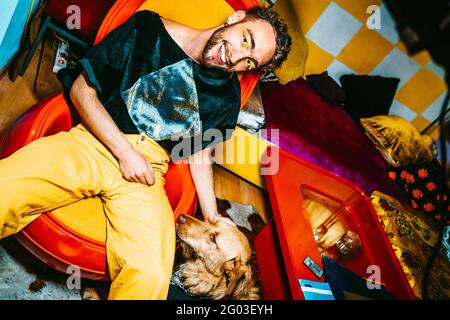 Ritratto di giovane sorridente con cane in soggiorno Foto Stock