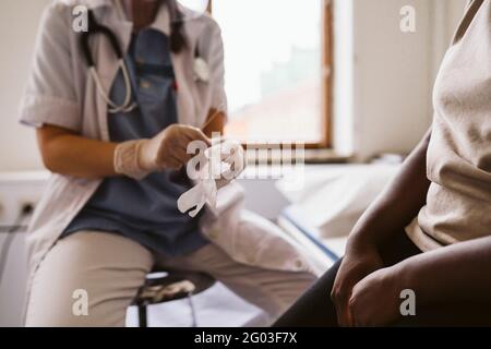 Donna esperta di medicina che indossa guanti protettivi Foto Stock