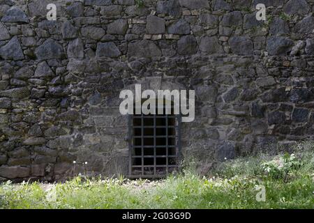 Chiuso Antique Old ferro barre porta su muro di pietra con barre. Concetto di uscita segreta. Foto Stock