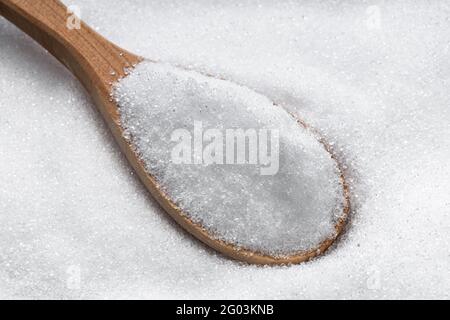 cucchiaio di legno con zucchero cristallino eritritolo sostituto primo piano mucchio di zucchero Foto Stock