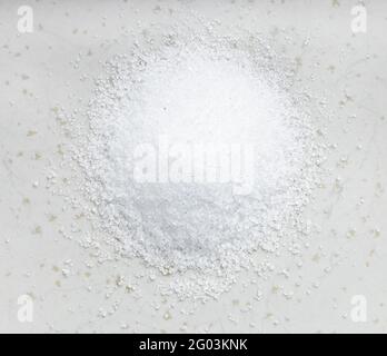 vista dall'alto del cumulo di sostituto dello zucchero - estratto cristallino di pianta di stevia primo piano su piastra di ceramica grigia Foto Stock