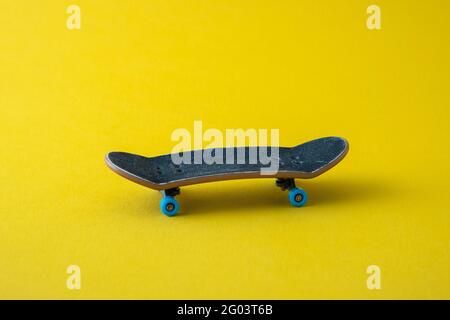 Mini skateboard su sfondo giallo Foto Stock