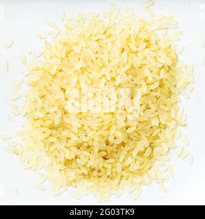 vista dall'alto di un mucchio di riso crudo parboiled da vicino su piastra in ceramica grigia Foto Stock
