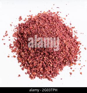 vista dall'alto di un mucchio di spezie di sumac da vicino su piastra in ceramica grigia Foto Stock