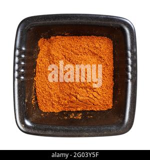 vista dall'alto del peperoncino in polvere dal pepe di cayenna in nero ciotola isolata su sfondo bianco Foto Stock