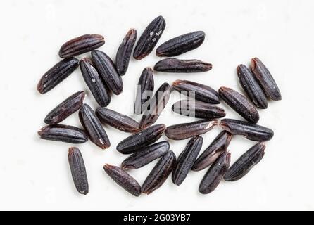 diversi grani di riso nero grezzo si avvicinano alla ceramica grigia piastra Foto Stock