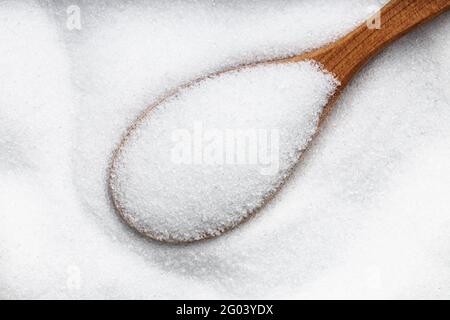 vista dall'alto del cucchiaio di legno con zucchero sostituto - cristallino estratto di pianta di stevia vicino su palo Foto Stock