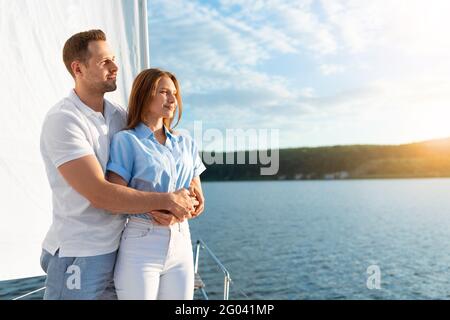 Coppia amorevole godendo della barca a vela Ride Hugging in piedi su Yacht Deck Foto Stock