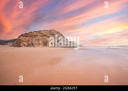 Bellissima spiaggia di sabbia e scogliera al tramonto. Panorama costa atlantica. Foto Stock