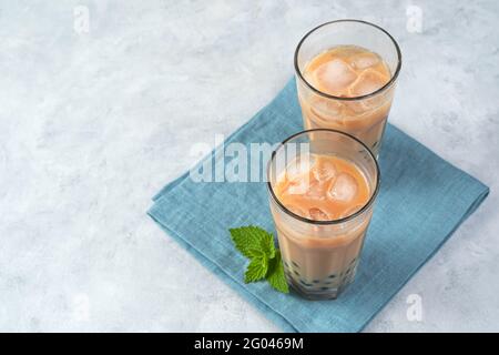 Tè bolla latte con perle di tapioca su sfondo grigio. Vista orizzontale, spazio di copia. Foto Stock