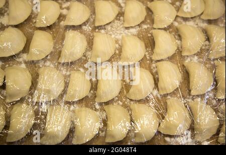 I gnocchi sono disposti per cucinare, cibo slavo. Piatto nazionale ucraino. Piatto tradizionale il processo di produzione di gnocchi. Impasto. Farina. Foto Stock