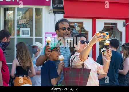 Windsor, Berkshire, Regno Unito. 31 maggio 2021. Selfie e gelati. Windsor era piena di gente del posto e di visitatori oggi, mentre il caldo sole ha portato le persone in città per il lunedì delle festività. Dopo la vita della maggior parte delle restrizioni del Covid-19 la città era in piena espansione oggi con le persone che mangiavano all'aperto, che andavano in gite fluviali e che si divertono con le loro famiglie e gli amici. Credit: Maureen McLean/Alamy Live News Foto Stock