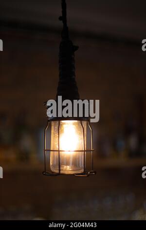 Lampada in paralume a griglia metallica, vecchia lampada da terra su sfondo marrone sfocato Foto Stock