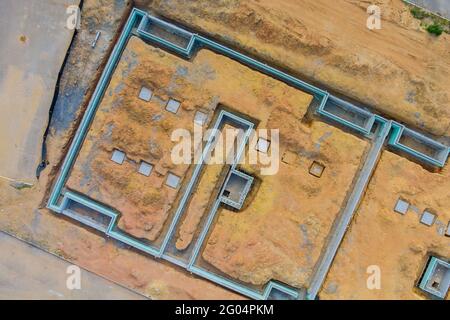 Vista aerea sulla preparazione del lavoro per il non finito con la fondazione per la costruzione di nuove case nei sobborghi Foto Stock