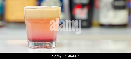 Una bevanda colorata a strati sparata su un bar preparato da barman, tempo di festa Foto Stock