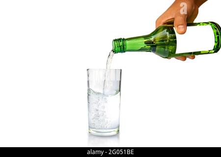 Concetto di stile di vita sano. Mano di giovane donna che tiene una bottiglia per versare l'acqua di vetro separatamente su sfondo bianco. Foto Stock