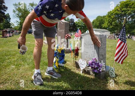 Grove, Stati Uniti. 31 maggio 2021. Ray Pack spolverò la sporcizia dalla tomba di suo zio John, che era un membro dell'esercito degli Stati Uniti, e che insegnò anche a Pack come cacciare e pescare. Ray Pack, 67 anni, di Grove City visita alcune tombe dei suoi amici e familiari il Memorial Day. Pack non servì mai in esercito, ma lui e un amico si unirono. Pack non era consentito ai militari, ma l'amico con cui ha firmato era e più membri della sua famiglia immediata erano anche membri del servizio militare compreso suo zio, fratello e padre. Credit: SOPA Images Limited/Alamy Live News Foto Stock