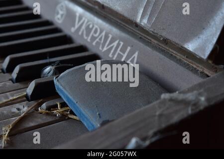 24 dicembre 2020, Zaitsevo, Donetskaya regione, Ucraina: Una vista di un pianoforte del marchio Ucraina che è stato lasciato in una casa vuota, è stato fatto in URSS. Sulle chiavi è una parte della Bibbia cristiana - il nuovo Testamento.nel corso degli ultimi sette anni, un certo numero di insediamenti in Ucraina orientale sono praticamente scomparsi dalla mappa del paese, e molti sono sul punto di scomparire nell'oblio. Ciò è dovuto al fatto che i residenti si stanno allontanando dai campi di baraccellatura e dai campi minati. Per quanto riguarda gli alloggi distrutti e abbandonati, sono in fase di smantellamento da parte dei bisognosi e dei saccheggiatori. (Immagine di credito: © Foto Stock