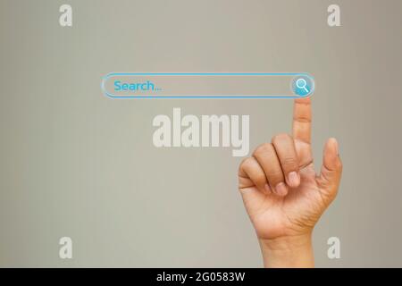 Un uomo d'affari fa clic su un touch screen del computer e inserisce un termine di ricerca alla ricerca di informazioni che navigano il concetto di business internet. Foto Stock