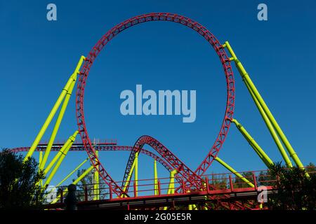 Anello di montagne russe rosse con colonne gialle su cielo blu sfondo Foto Stock