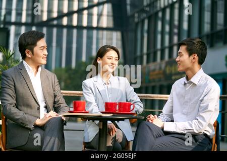 tre imprenditori asiatici che discutono di affari all'aperto in caffè colpo Foto Stock