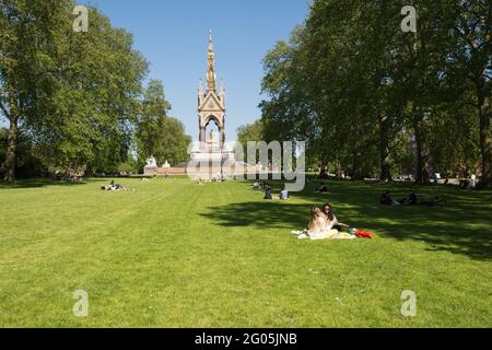 Le persone che si rilassano il lunedì delle festività di fronte all'Albert Memorial, Kensington Gardens, Kensington, Londra, W8, Inghilterra, Regno Unito Foto Stock