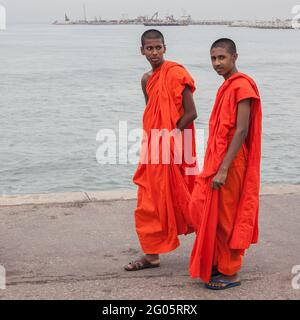 Due giovani monaci buddisti posano per scattare foto mentre camminano lungo Galle Face, Colombo, Sri Lanka Foto Stock