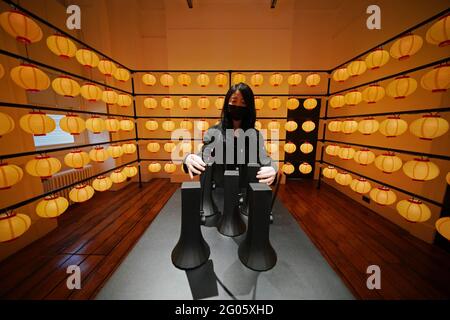 Un membro dello staff della mostra si pone nell'installazione Swingphony, durante una telefonata per la London Design Biennale alla Somerset House di Londra, che va dal 1 al 27 giugno. Data immagine: Martedì 1 giugno 2021. Foto Stock