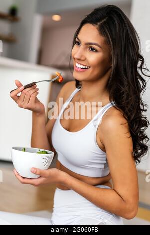 Montare bella donna mangiare sano insalata dopo allenamento fitness Foto Stock