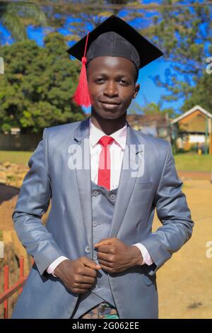 KAMPALA, UGANDA - 31 maggio 2021: Il bell'uomo afroamericano si è diplomato nel suo giorno di laurea, mentre ci divertiamo e proviamo diverse foto lo pone Foto Stock