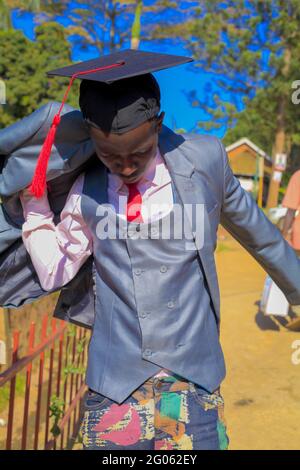 JINJA, UGANDA - 31 maggio 2021: Il bell'uomo afroamericano si è diplomato nel suo giorno di laurea come abbiamo divertimento e provare diverse foto pone sguardo Foto Stock