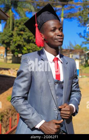 KAMPALA, UGANDA - 31 maggio 2021: Il bell'uomo afroamericano si è diplomato nel suo giorno di laurea, mentre ci divertiamo e proviamo diverse foto lo pone Foto Stock