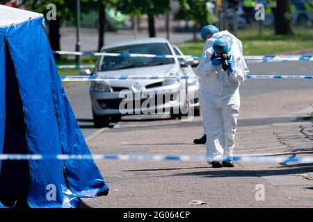 Un ufficiale forense scatta fotografie sulla scena di College Road, Kingstanding, a nord di Birmingham, dove un ragazzo di 14 anni è morto dopo essere stato pugnalato il lunedì sera. La polizia ha avviato un'indagine sugli omicidi e sta cacciando fino a sette persone in relazione all'attacco. Data immagine: Martedì 1 giugno 2021. Foto Stock