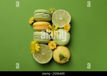 Macaroni, lime e fiori su sfondo verde Foto Stock