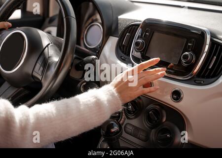 Donna mano che spinge lo schermo del monitor in auto Foto Stock