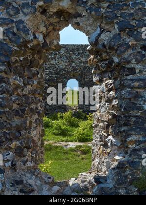 Una vista attraverso una finestra della torre di Nettuno abbandonata e rovinata, Kingsgate, le pareti di pietra e Malta ricoperte di edera, luce del sole e ombre. Foto Stock