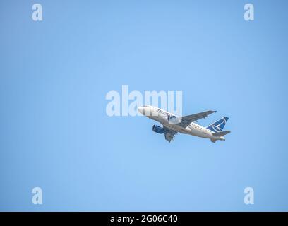 Bucarest, Romania - 04.29.2021: Aereo Tarom Airbus A318-111 (YR-ASC) che vola contro il cielo blu. Foto Stock