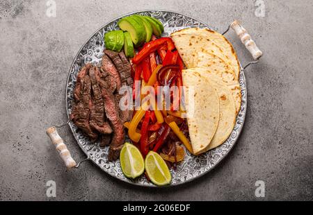 Piatto messicano fajitas di manzo con tortillas dall'alto Foto Stock