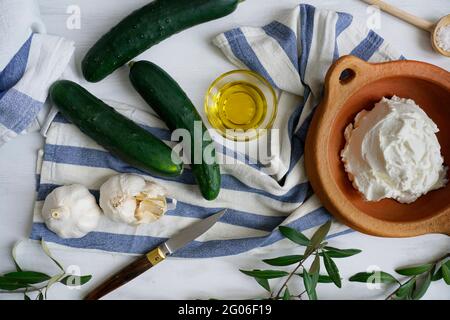Ingredienti per la preparazione di tzatziki, salsa tradizionale greca a base di aglio, yogurt, cetriolo, olio extravergine di oliva, sale Foto Stock