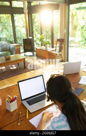 Ragazza asiatica che usa il laptop con schermo vuoto, scrittura, apprendimento online Foto Stock