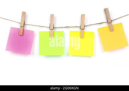 Nota pad in molti colori, appendere con corda, hanno vestiti spina, copia spazio per lettere e testi su sfondo bianco Foto Stock