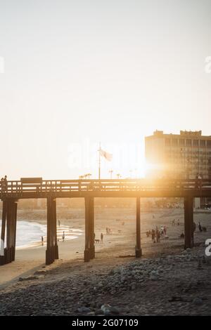 VENTURA, STATI UNITI - 31 maggio 2021: Bandiera americana sventolando su un molo a Ventura California con il sole che tramonta dietro di esso. Foto Stock