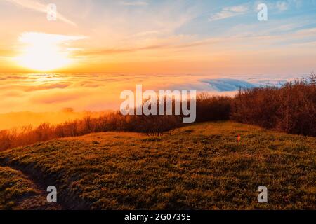 Nuvole striscianti con tramonto in montagna. Foto Stock