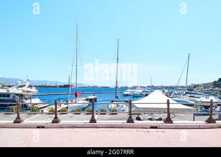 Messina, Sicilia, Italia - 26 aprile 2021: Porto di Messina con barche ormeggiate, statua dorata della Madonna della Lettera e costa calabrese sullo sfondo. Foto Stock