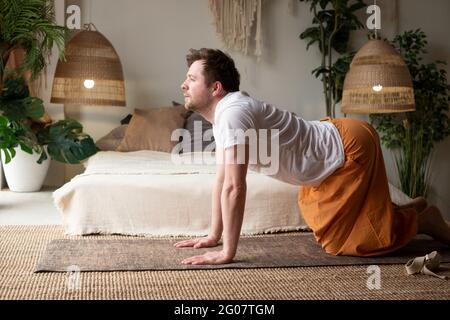 L'uomo pratica yoga asana marjariasana o posa di mucca o posa di mucca di gatto per la spina dorsale Foto Stock