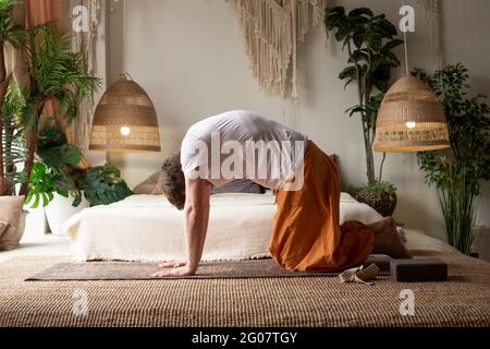 L'uomo pratica yoga asana marjariasana o posa di mucca o posa di mucca di gatto per la spina dorsale Foto Stock