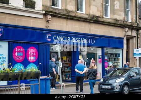 Callander, Scozia - 29 maggio 2021: Il fronte del negozio e segno per Cancer Research UK Foto Stock