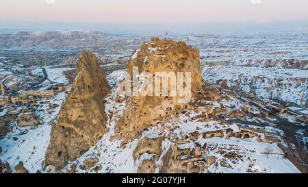 Vista aerea di formazioni rocciose ricoperte di neve bianca contro il cielo notturno senza nuvole in Cappadocia, Turchia Foto Stock