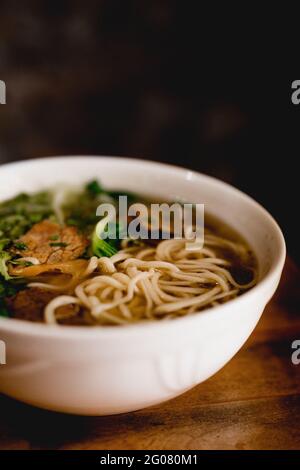 Da sopra grande ciotola bianca di ceramica di zuppa di ramen di manzo Foto Stock